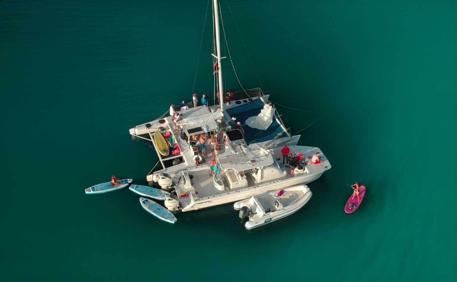 Aerial drone view of the Carolina Moon catamaran anchored on emerald Florida Bay with paddleboards alongside