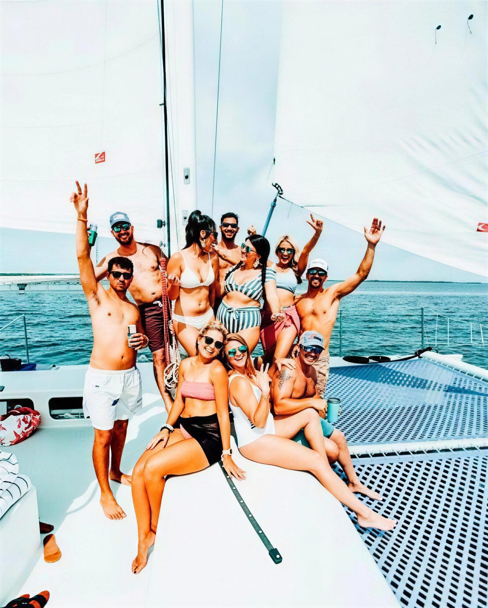 A group of friends cheering and raising drinks aboard the Carolina Moon catamaran on a private Key Largo charter
