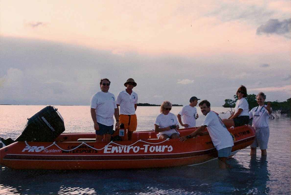 The Enviro-Tours crew in white shirts standing aboard the original red inflatable boat