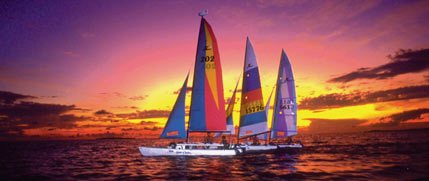 Hobie catamarans silhouetted against a blazing orange and purple Key Largo sunset
